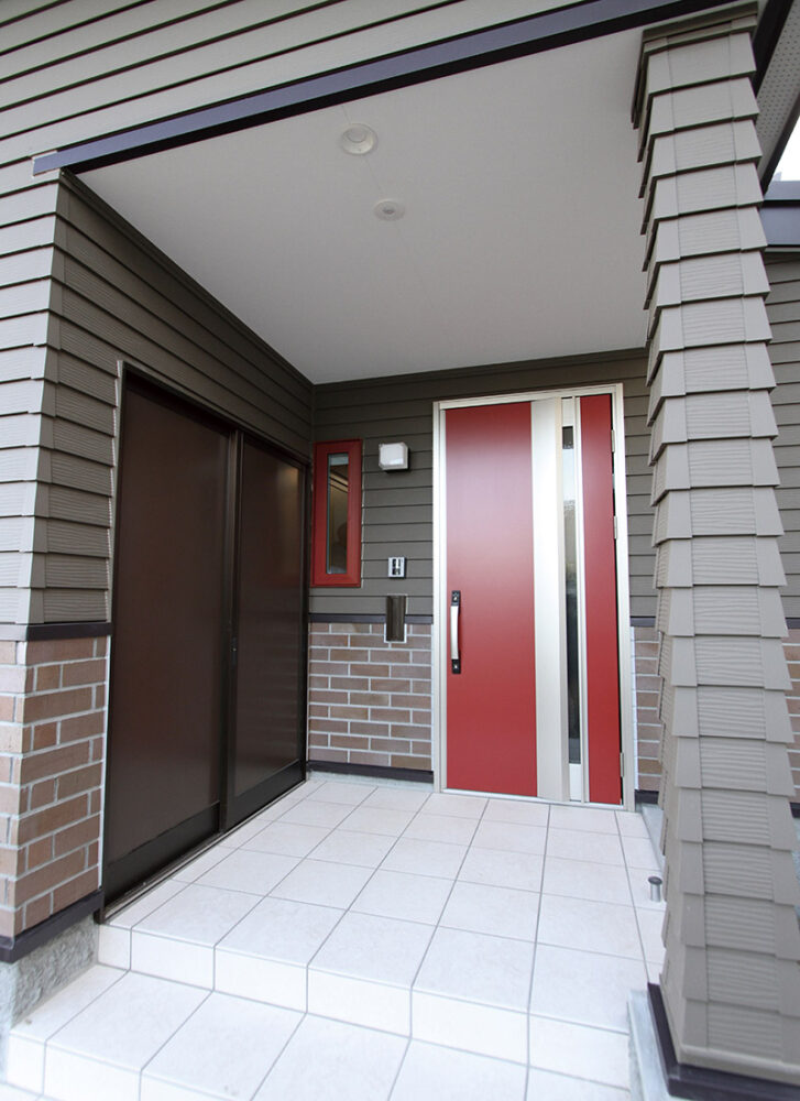 玄関まわりのデザインは、玄関ドアと小窓の枠の赤がアクセントに