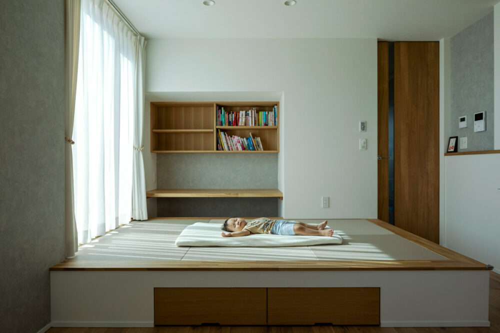 リビングの一角に設けた小上がりは、階段下を利用して本棚とカウンターを設置。今はお昼寝に便利で、将来的には子どもたちの勉強机として活用できる。床下にも収納を設けた
